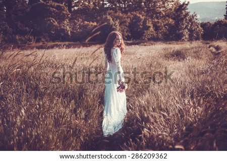 Portrait of young woman in the spring time. Almond flowers blossoms. Girl dressed in white like a bride.