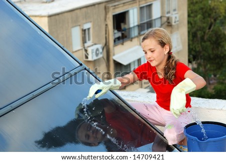 Girl on the roof cleaning the solar battery
