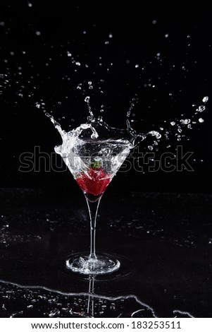 Strawberry splashing into martini glass