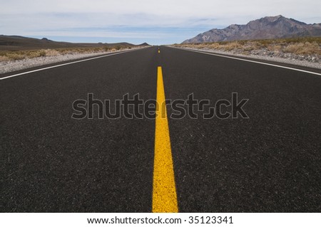 clean straight road through desert vanishing into distance