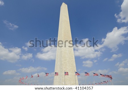 washington monument in Washington DC against blue sky with american flags circling it