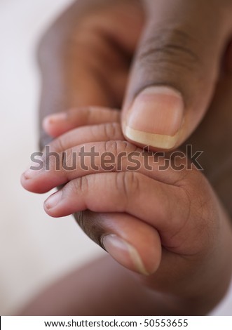 close up of an african american baby hand in mother\'s hand