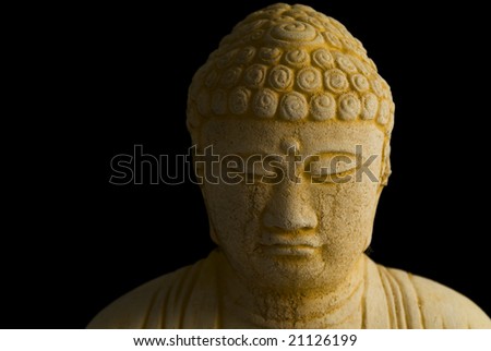Front view head shot of Buddha face on black background