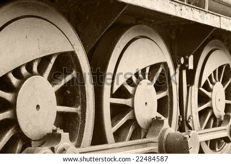 Side view of steam train wheels in sepia