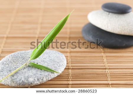 bamboo leaf and a stack of stones on a bamboo mat