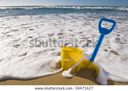 Beach scene, Spade and bucket at the waters edge.