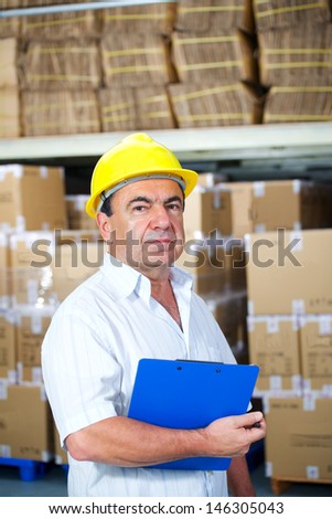 storekeeper in helmet at work in warehouse