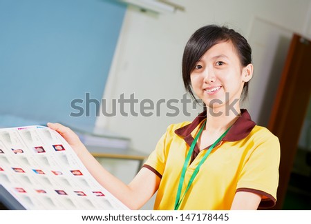 Happy Asian girl holding a proofing in printing house