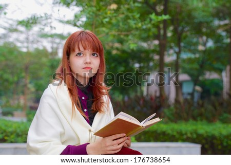 girl reading a book in the autumn garden