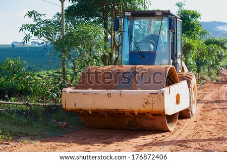 Road construction machinery in the village road to the tea fields