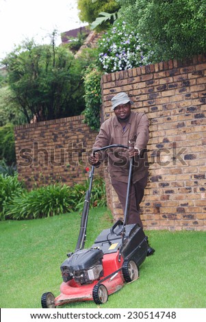 Man cutting grass in a garden yard with lawn mower