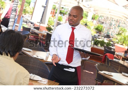 Waiter taking an order from customer in restaurant