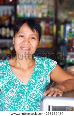 Vertical portrait of a vietnamese woman seller mini market
