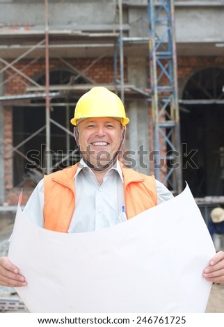 Builder in helmet with a drawing plan vertical photo