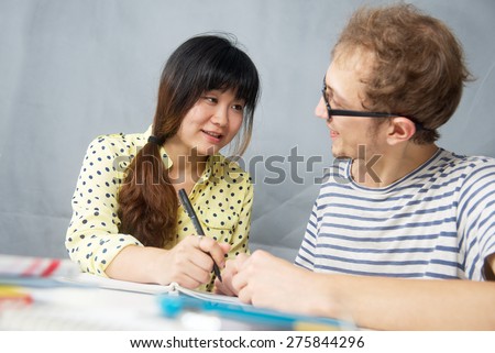 Caucasian young man talking with a Chinese girl is language teacher