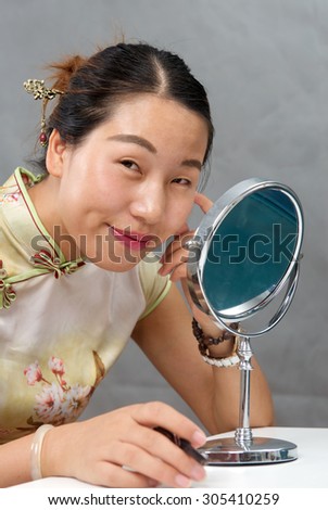 Asian girl smiling in the mirror