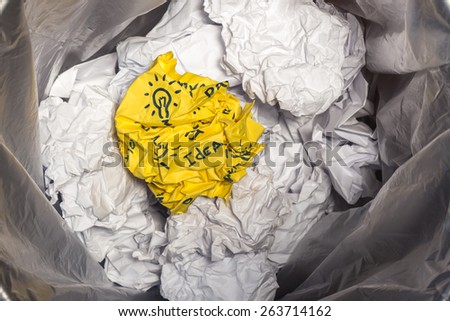 Office waste basket with crumpled colored  paper balls background.