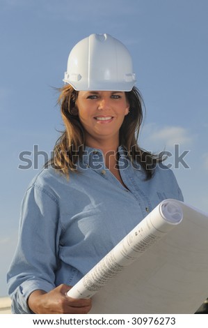 Woman construction worker holding a set a blueprints