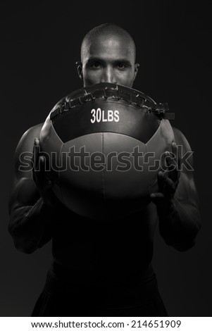Black and white portrait of a fitness trainer, holding a medicine/fitness ball