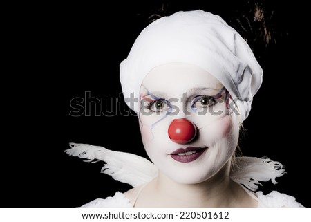 Young woman dressed as a happy clown, with angels wings and white underwear on her head