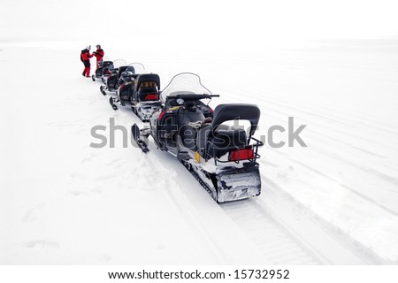 snowmobile stop in a single file in the snowfield.