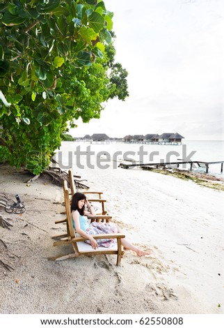 asian girl sitting in the chair on maldives beach