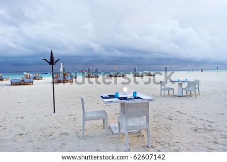 dining table on the sand beach in maldives resort