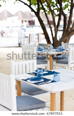 outdoor dining tables on the sand beach in maldives resort