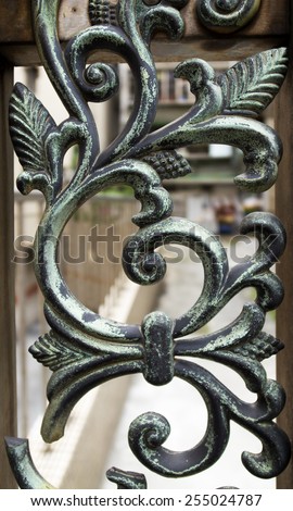 Wrought iron railing. Shapes of leaf and elegant curves. Dark green color.