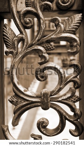 Wrought iron railing. Shapes of leaf and elegant curves. Sepia toned image.