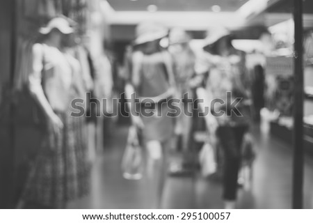 Black and white, de focused/Blur image of boutique window with dressed mannequins. Boutique display window with mannequins in fashionable dresses.
