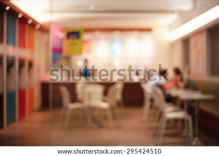 De focused/Blur image of a restaurant with a coupe of lovers in it. Blurred people in restaurant. Blurred background of lovers sitting in the restaurant.