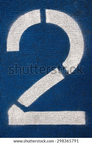 Number two on a running track. White number on blue background.