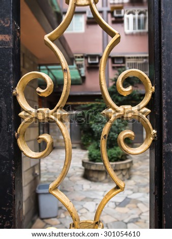 Wrought iron railing in symmetrical pattern. Golden color.
