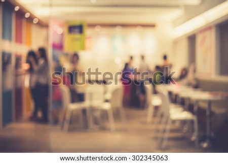 De focused/Blur image of a restaurant with customers in it. Blurred people in restaurant. Blurred background of people in the restaurant.  Retro effect.