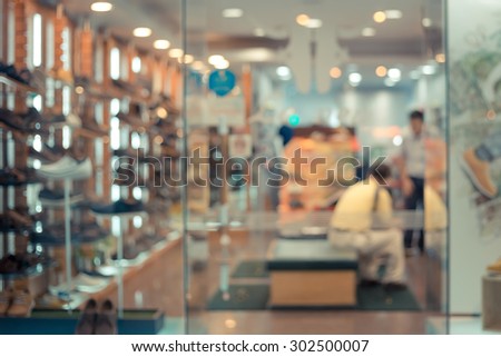 De focused/Blurred image of a shoe store with a staff and a customer in it.