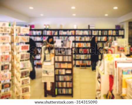 De focused/Blur image of a bookstore with customers reading and looking for books. Toned image. Warm tone.