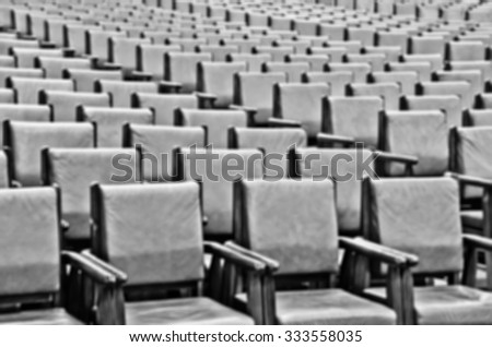 De focused/Blurred image of rows of chairs. Chairs background. Black and white image.