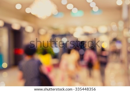 De focused/Blurred image of people leaving a department store. Department store background. Shopping mall background. Toned image.