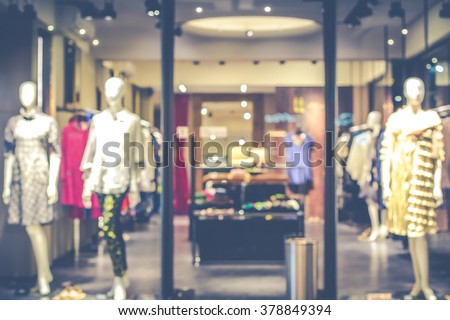 De focused/Blur image of boutique window with dressed mannequins. Boutique display window with mannequins in fashionable dresses. Toned image.