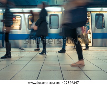 People getting off the subway train. Motion blur. City life. Toned image.