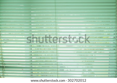 Sunlight coming through venetian blinds by the window.