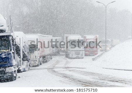 Trucks stopped on a highway during heavy snow storm