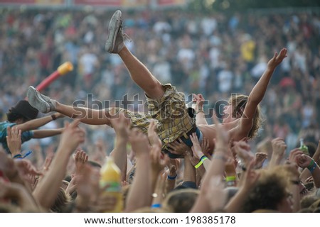 LA COURNEUVE, FRANCE - SEPTEMBER 16, 2011 - Young man raised by the crowd during the Fete de l\'Humanite, a french festival