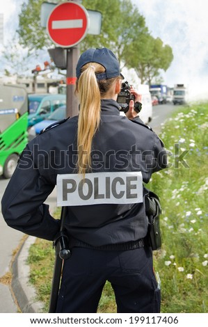 PARIS - MAY 20, 2014 - A french police woman control car speed with a mobile radar