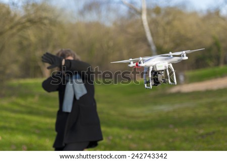 VERSAILLES, FRANCE - APRIL 18, 2015 - Drone scares woman flying around her