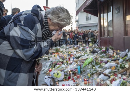 PARIS, FRANCE - NOVEMBER 15, 2015 :  An old woman very touched in front of the bar hotel Le Carillon near the theater Bataclan after the terrorist attack in Paris, November 13, 2015.