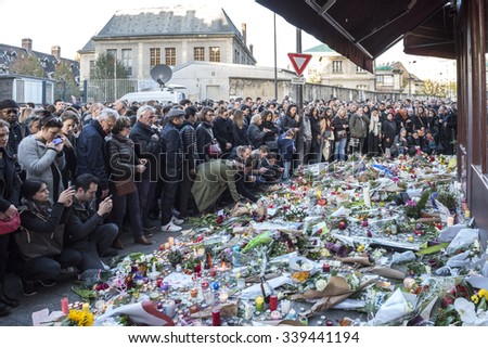 PARIS, FRANCE - NOVEMBER 14, 2015 :  People in front of the Bar Hotel Le Carillon street Alliber in tribute to victims of the Nov. 13, 2015 terrorist attack in Paris at the Bataclan.