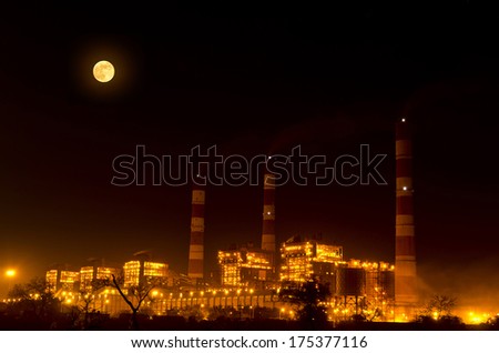 Power Industry Illuminated With Yellow Light And At The Same Time Full Moon Also Glowing And Spreading Its Light During Night