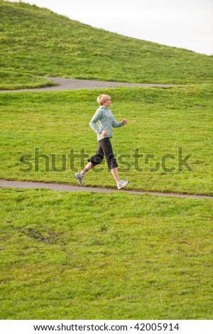 A female jogger coming down a hill